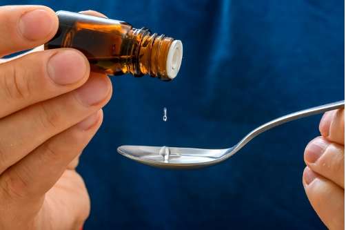 Putting essential oil on a spoon from a bottle