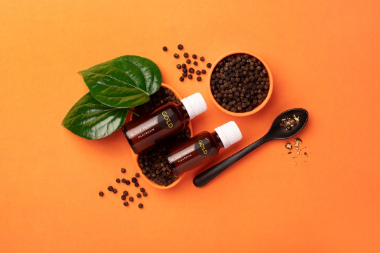 Goeld black pepper oil with spatula and leaf