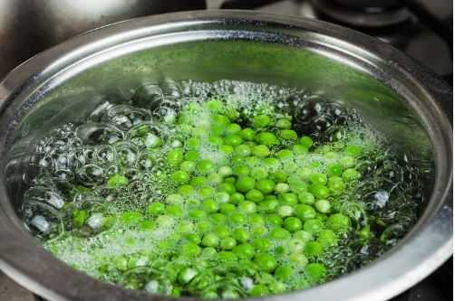 Thawing frozen green peas in cold water